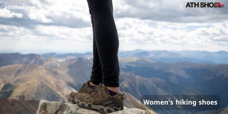 An image of a man wearing sneakers standing on top of a mountain included a discussion about Women's hiking shoes in Australia